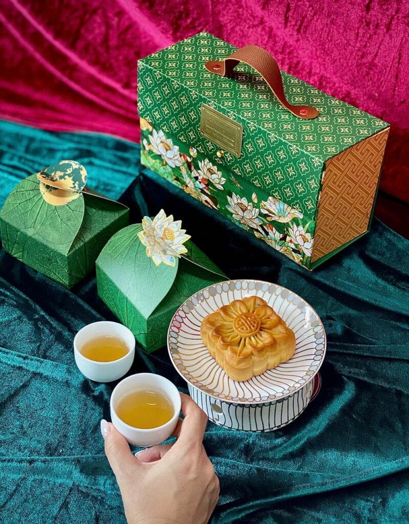 Hộp bánh trung thu Sen Gấm trên tay và trà
